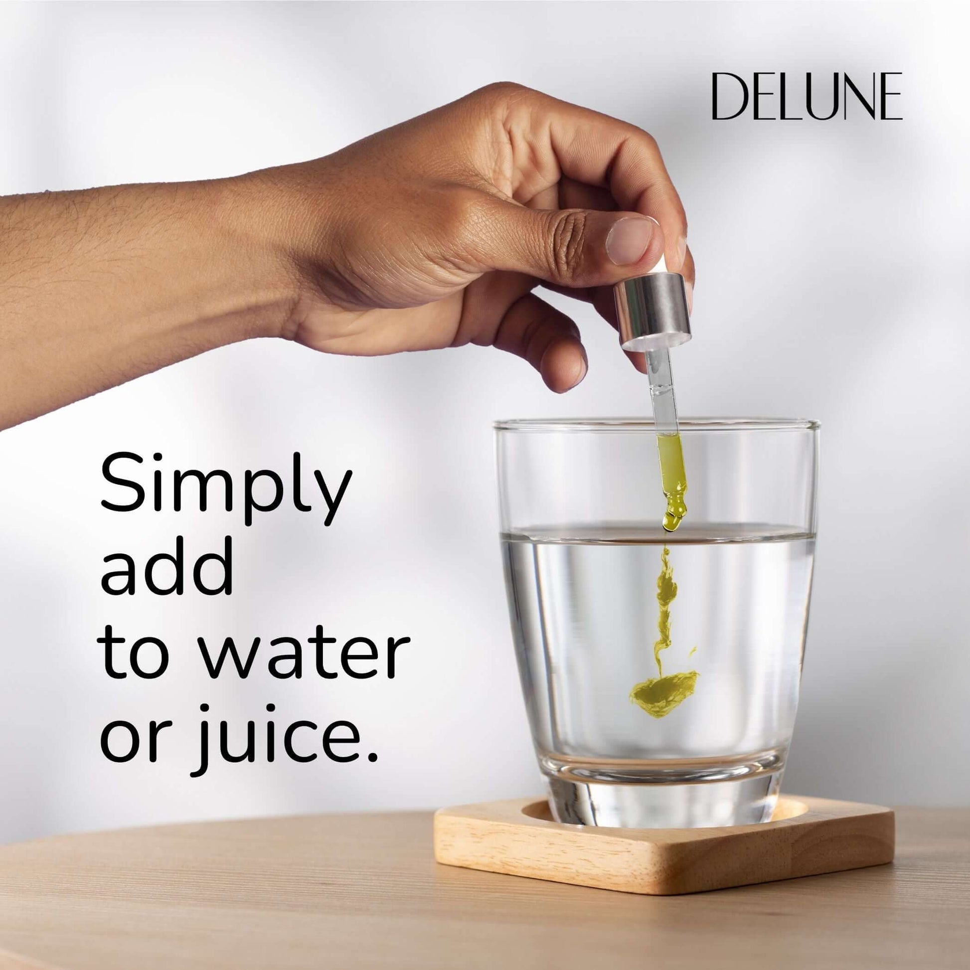 Hand adding herbal tincture to water with dropper, showcasing easy use of Organic Elderberry Herbal Tincture for immune boosting.