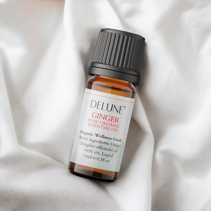 Ginger Organic Wellness Grade Essential Oil bottle on white fabric, 100% Zingiber officinale for vitality and energizing aroma.