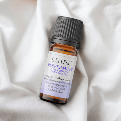 Peppermint Organic Wellness Grade Essential Oil bottle with label, resting on soft fabric, promoting alertness and vitality.